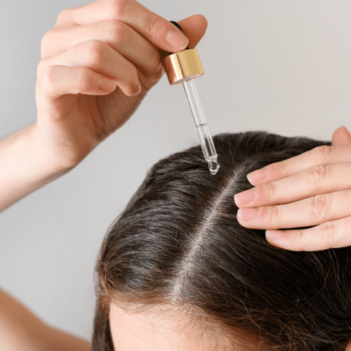 Mujer usando un aceite natural para su cabello