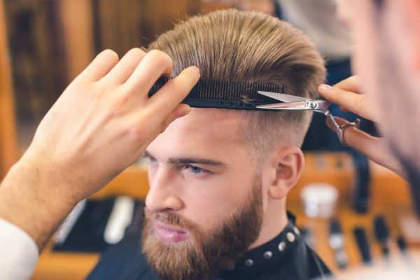 Barberia mientras peluquero cortando cabello