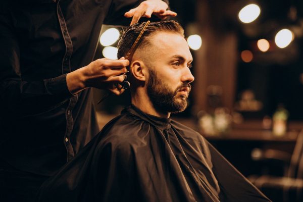 Hombre al cual le están cortando el cabello