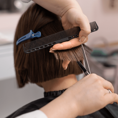 Mujer cortándose las puntas de los pelos